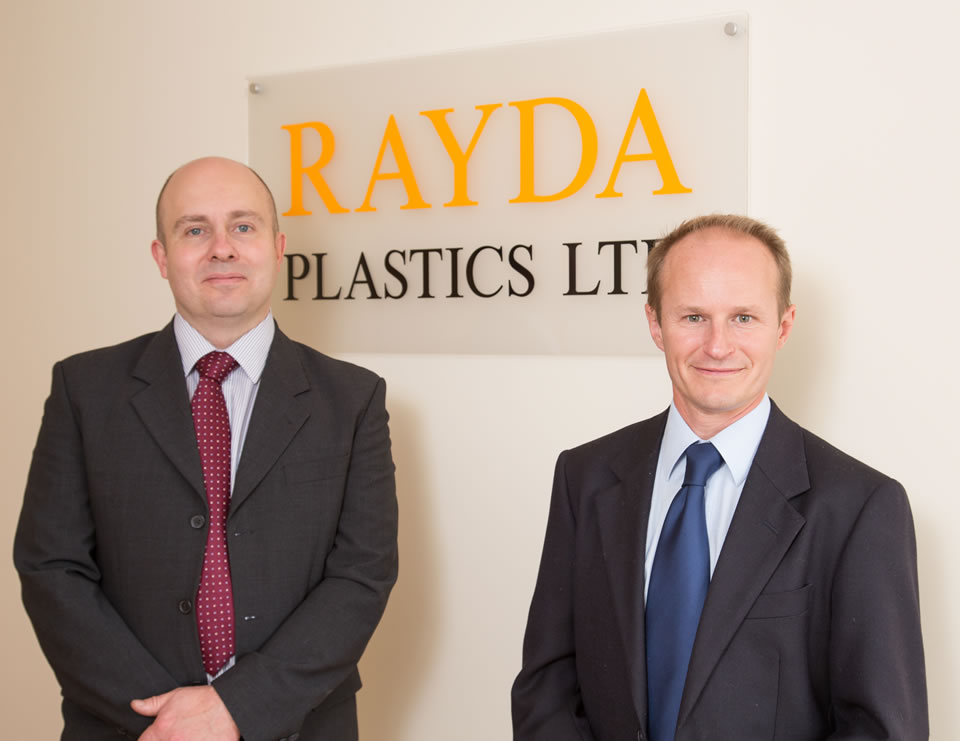 Rayda Plastics Management Team next to the company sign.